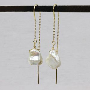 Durch die Ohrringperle ziehen