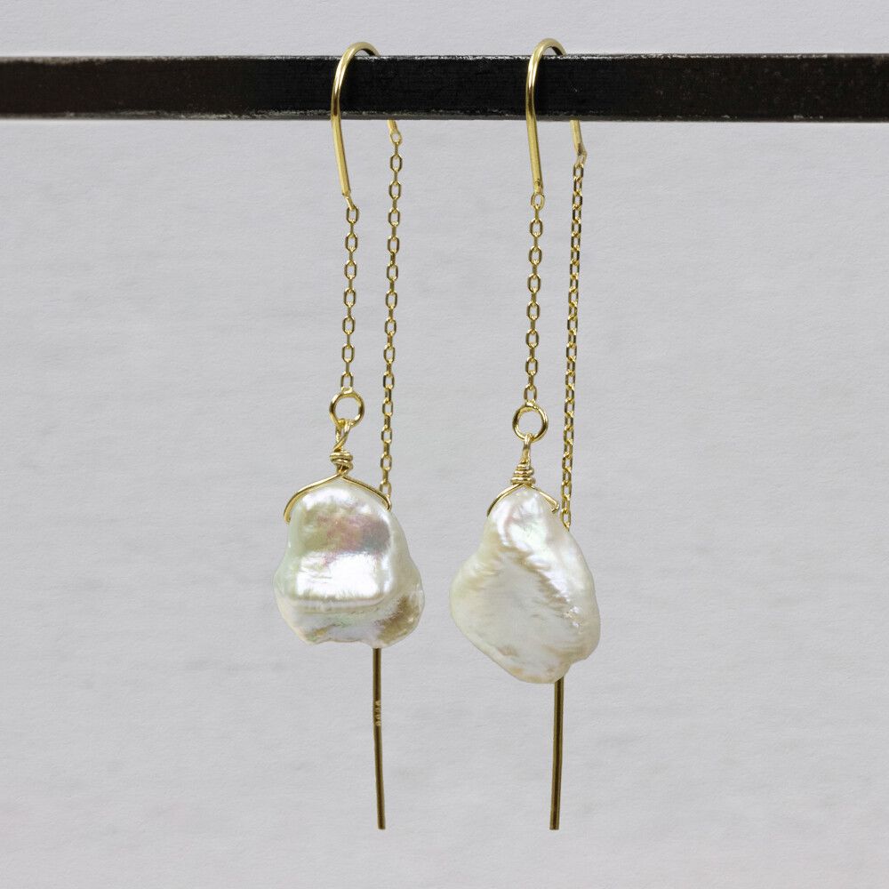 Durch die Ohrringperle ziehen