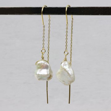 Durch die Ohrringperle ziehen